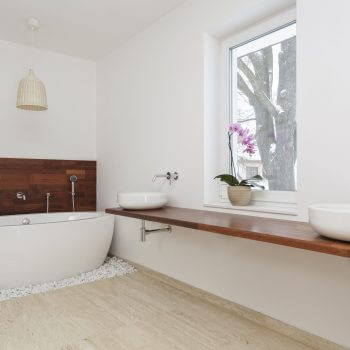 A bathroom with a wooden counter and a tub.