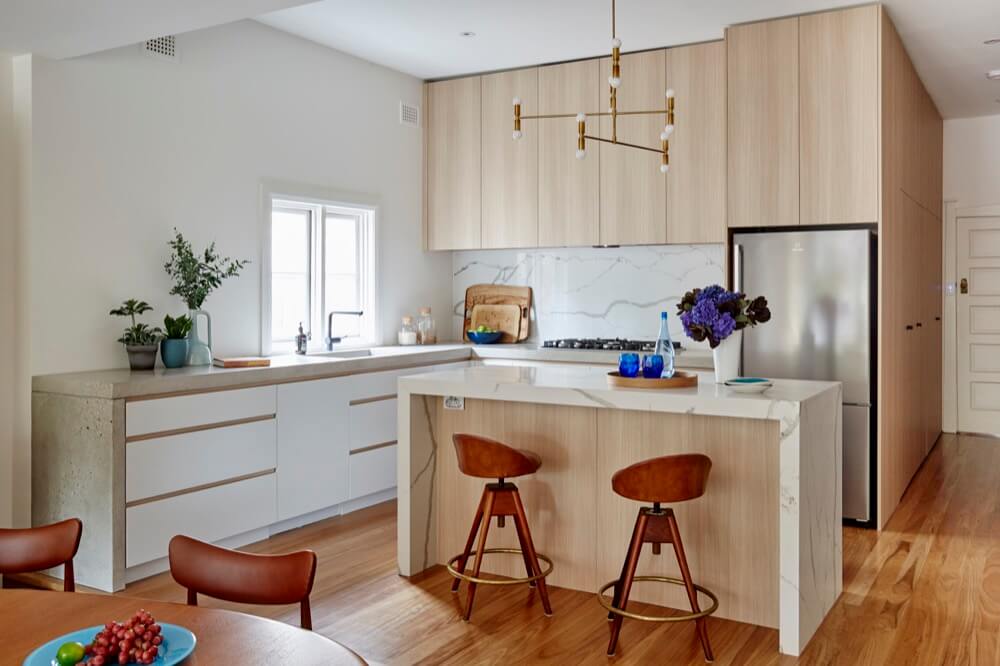 A kitchen with wooden cabinets and a bar stool.
