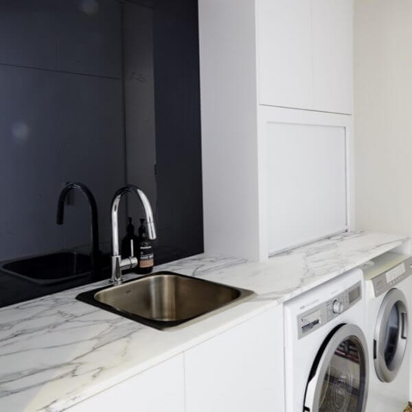 Small white laundry renovation ideas with white marble bench top finish