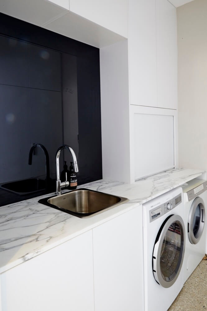 Small white laundry renovation ideas with white marble bench top finish