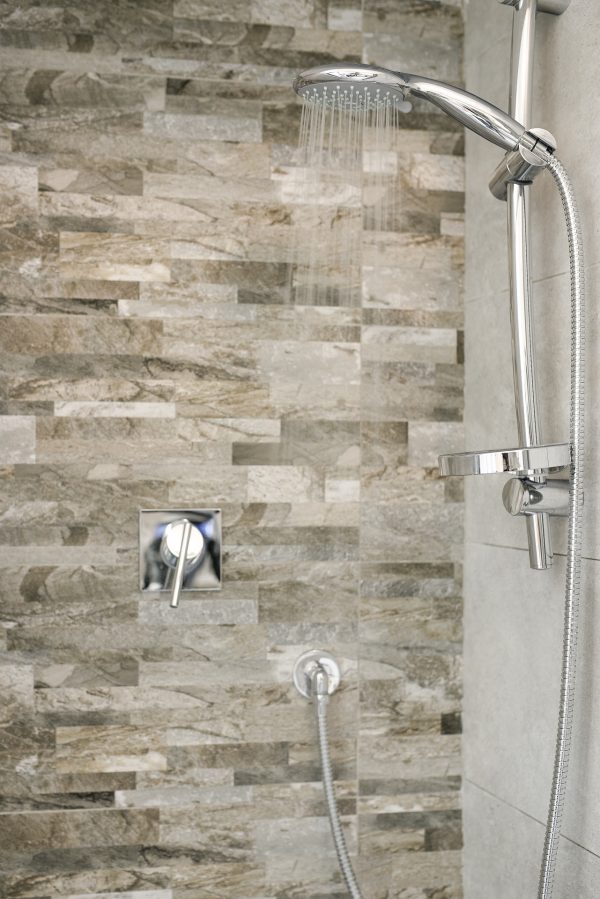 Phoenix Brass, Nickel, Black and Gold Tapware. Chrome shower head and hose with stone feature wall